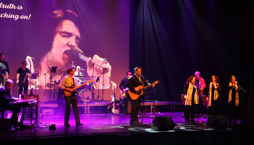 Et samspilt 'For The Heart Band' sprudlet av spilleglede som smittet over på publikum som var med på notene fra første tone. Musikere på scenen. Bilde av Elvis i bakgrunnen.